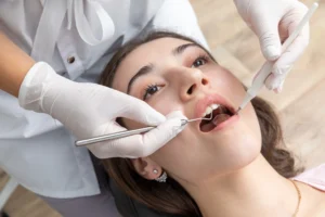 Dental professional examining a patient’s teeth with dental instruments